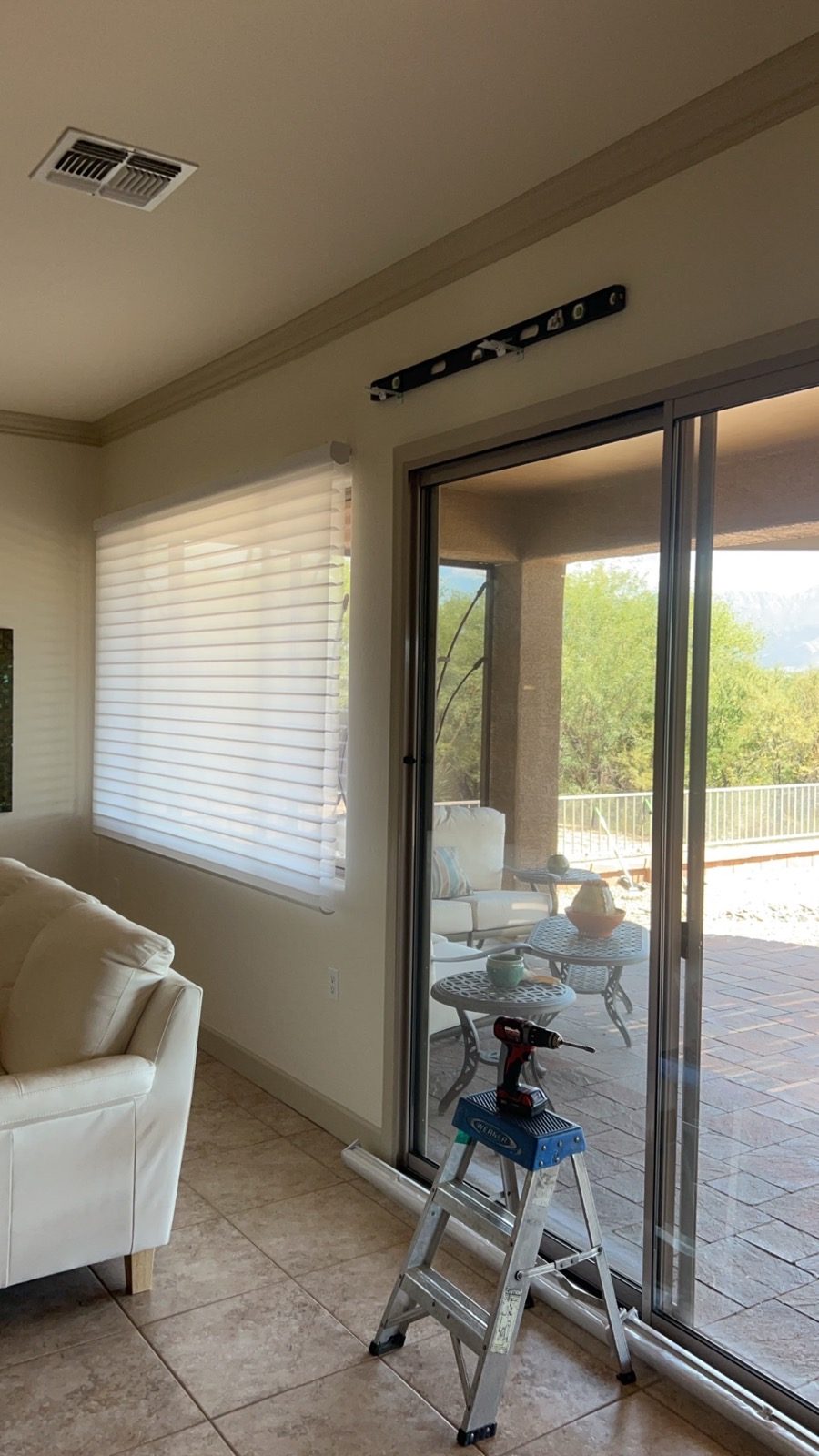 Light-filtering shade installation beside a patio slider in a Tucson home