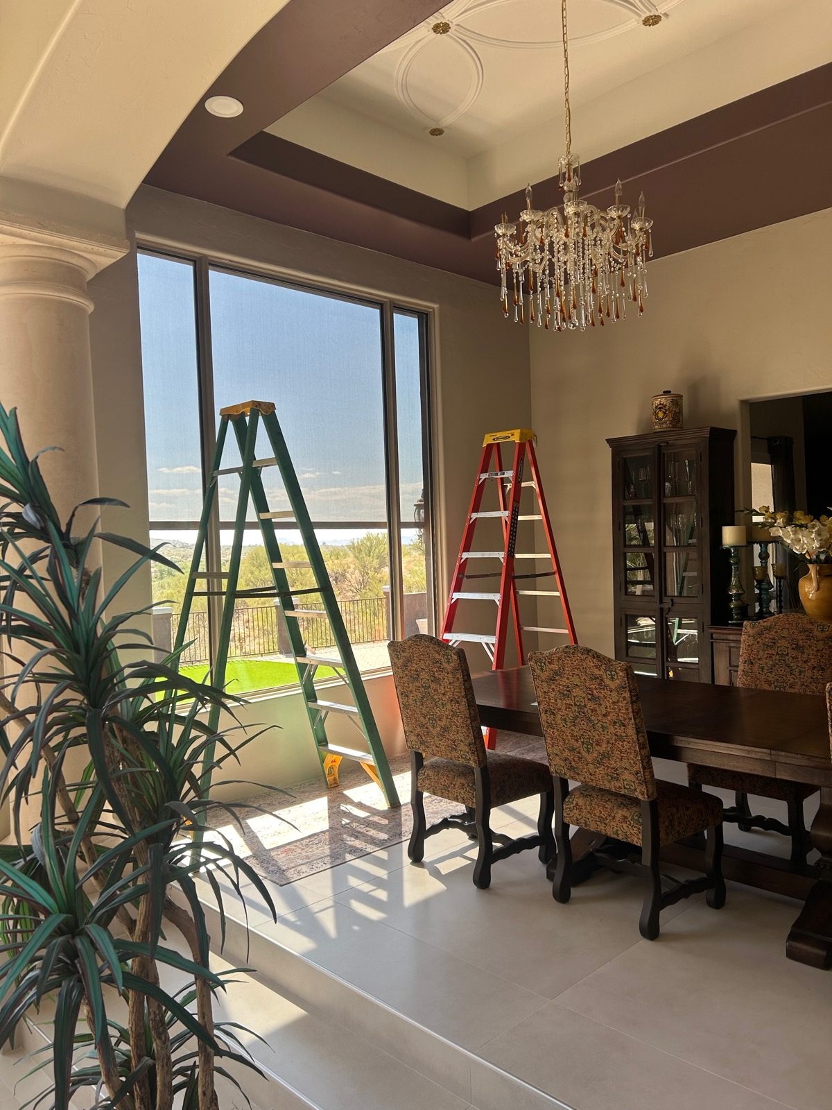 Floor-to-ceiling solar shades on tall windows in a Tucson dining room