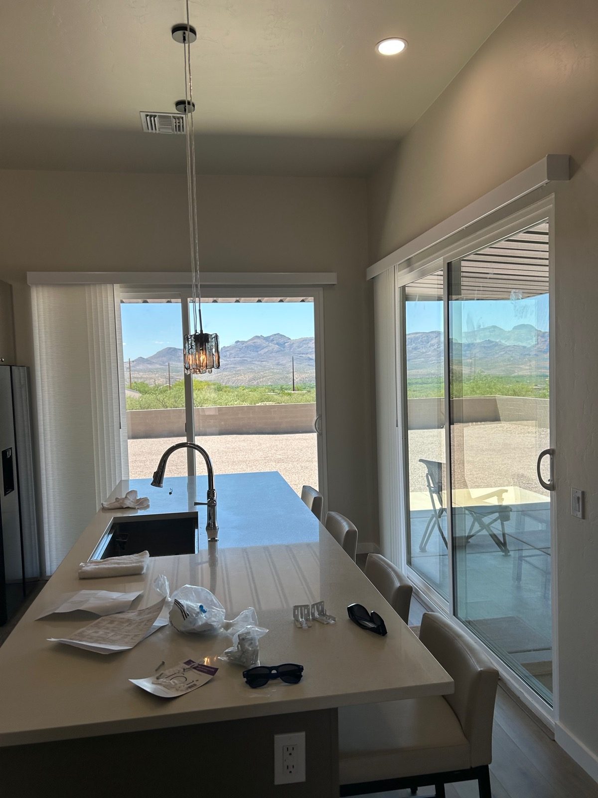Vertical blinds on sliding glass doors framing Catalina mountain views in a Tucson kitchen, installed by Love Is Blinds Arizona