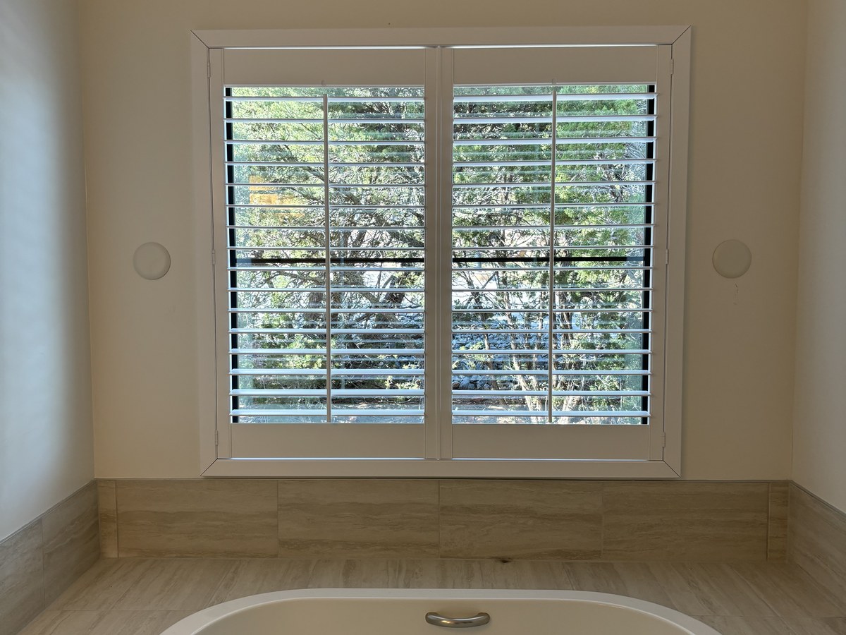 Plantation shutters in a bathroom by Love Is Blinds Arizona