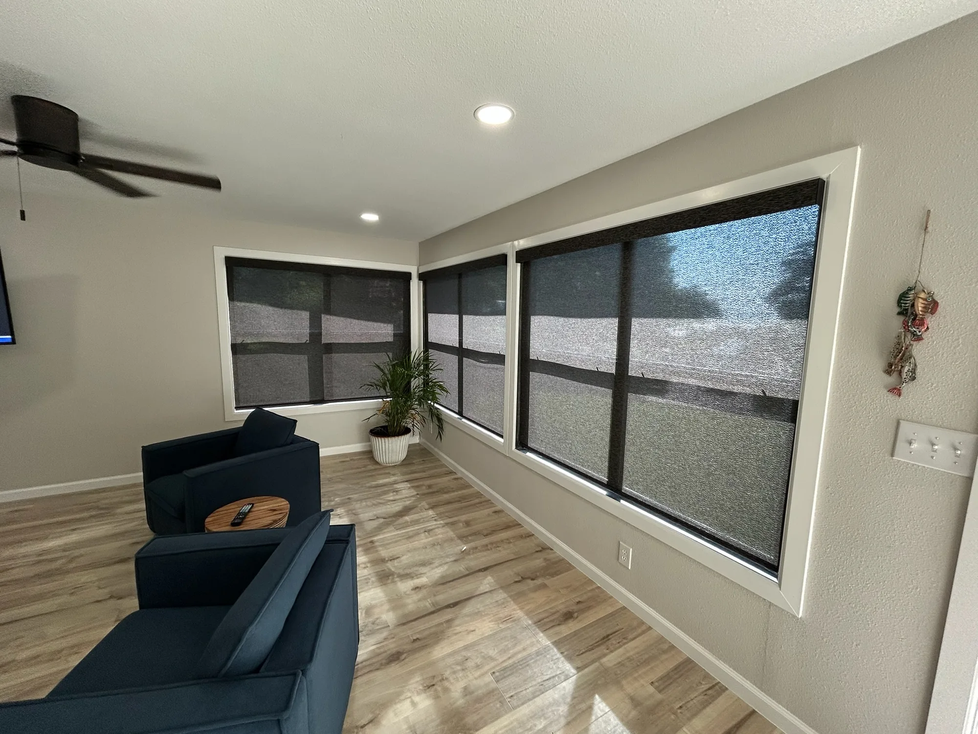 Den with solar roller shades installed by Love Is Blinds