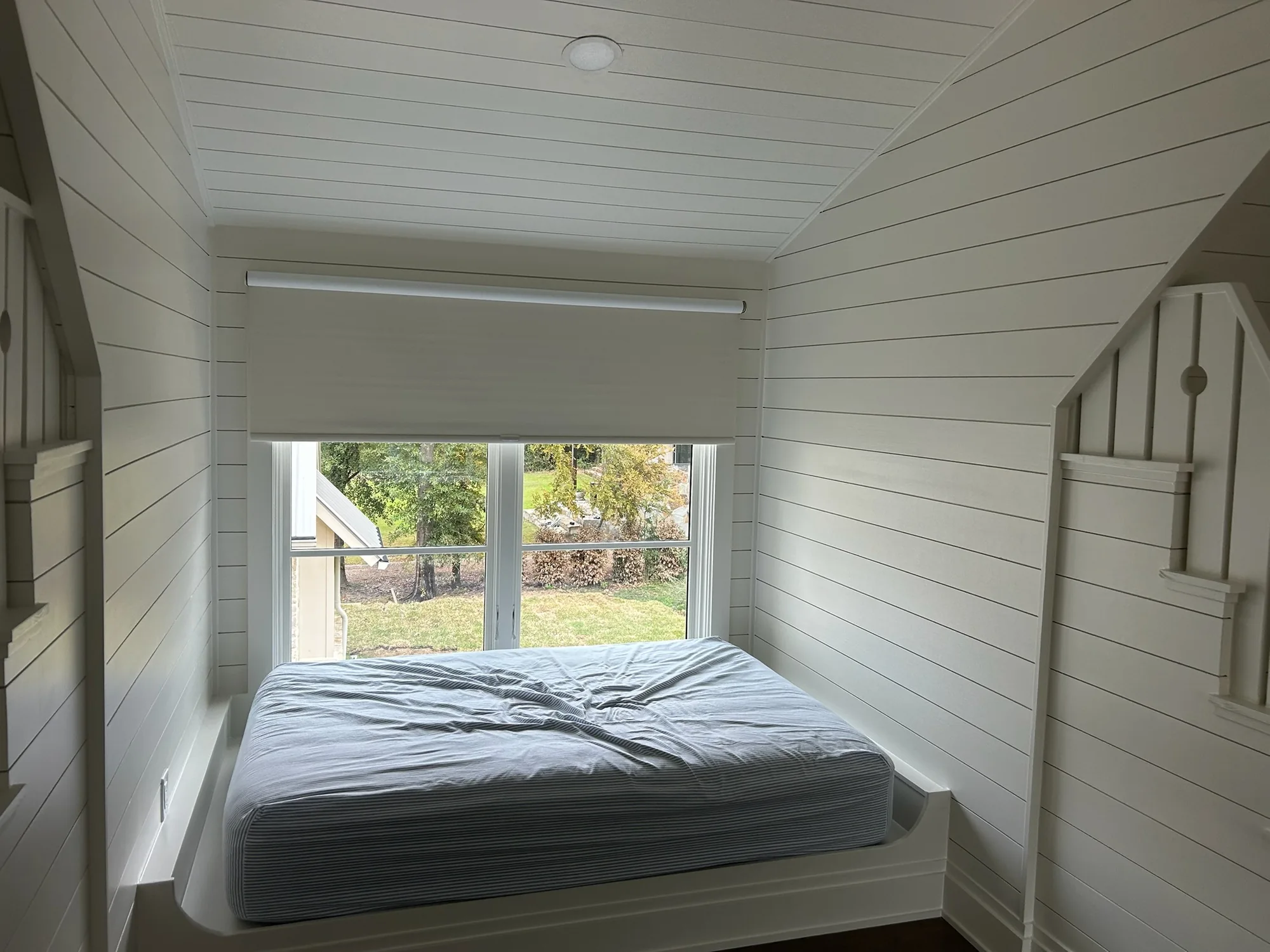 Bedroom with a custom roller shade installed by Love Is Blinds