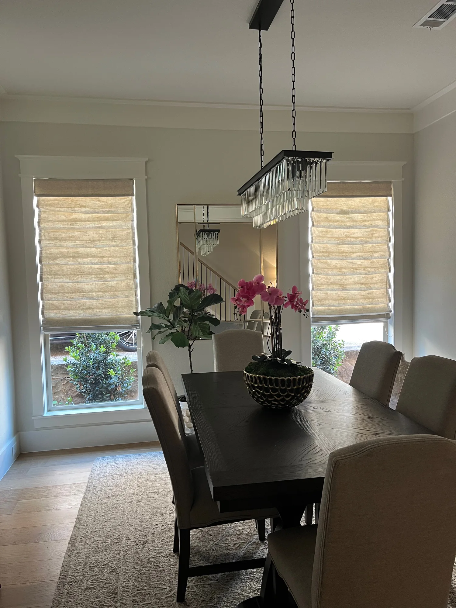 Dining room with a custom roman shade installed by Love Is Blinds