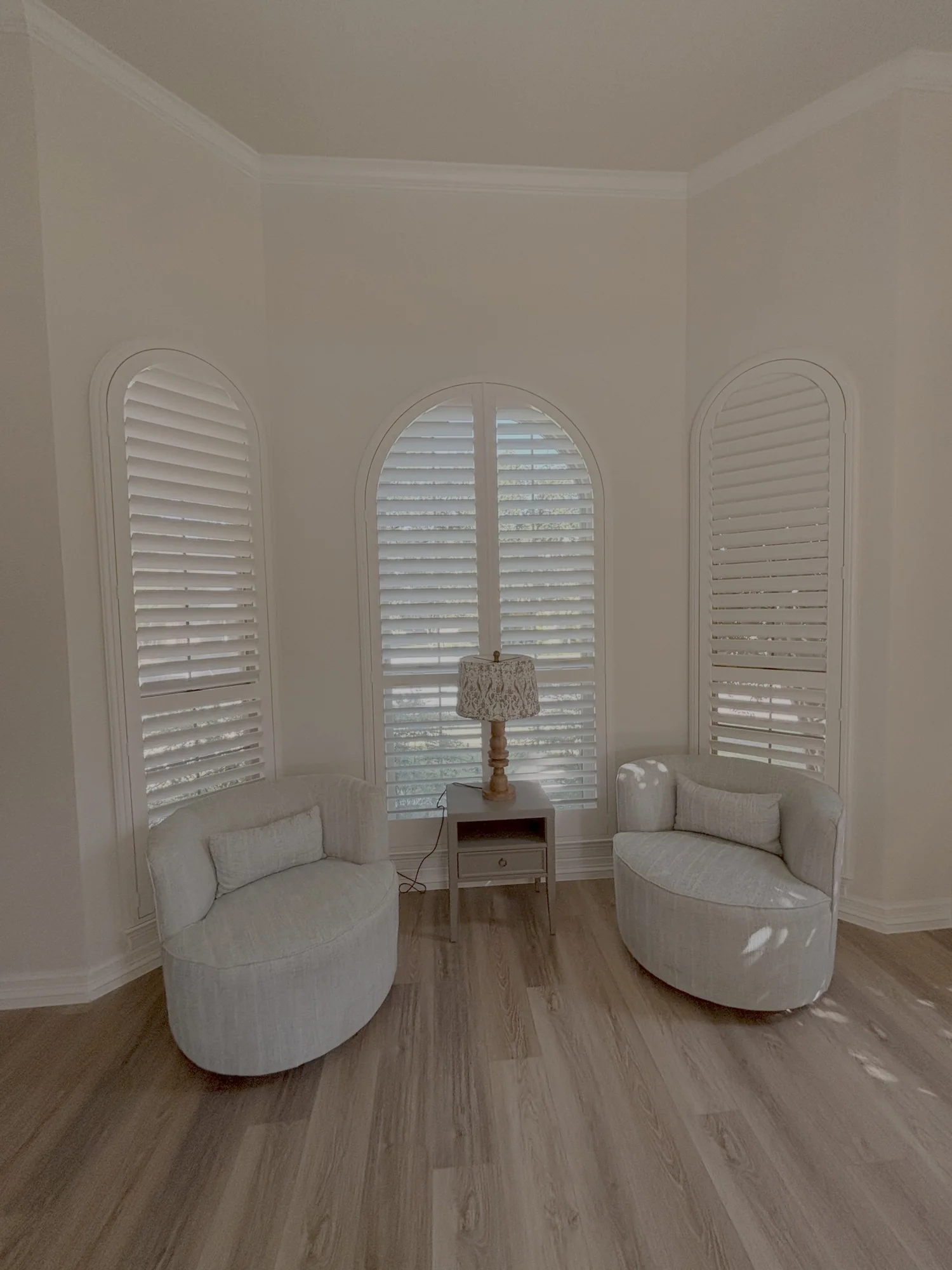 Arched windows with custom plantation shutters installed by Love Is Blinds