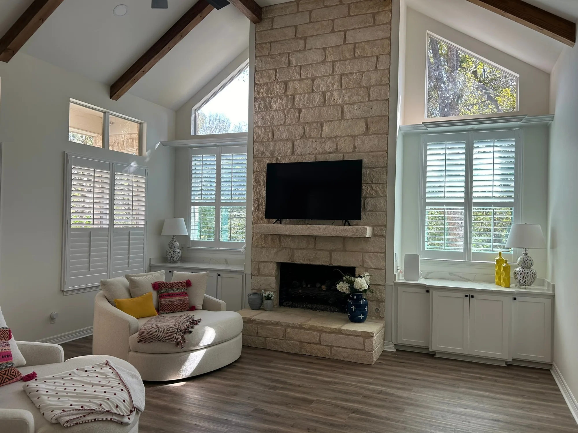 Vaulted living room with plantation shutters installed by Love Is Blinds