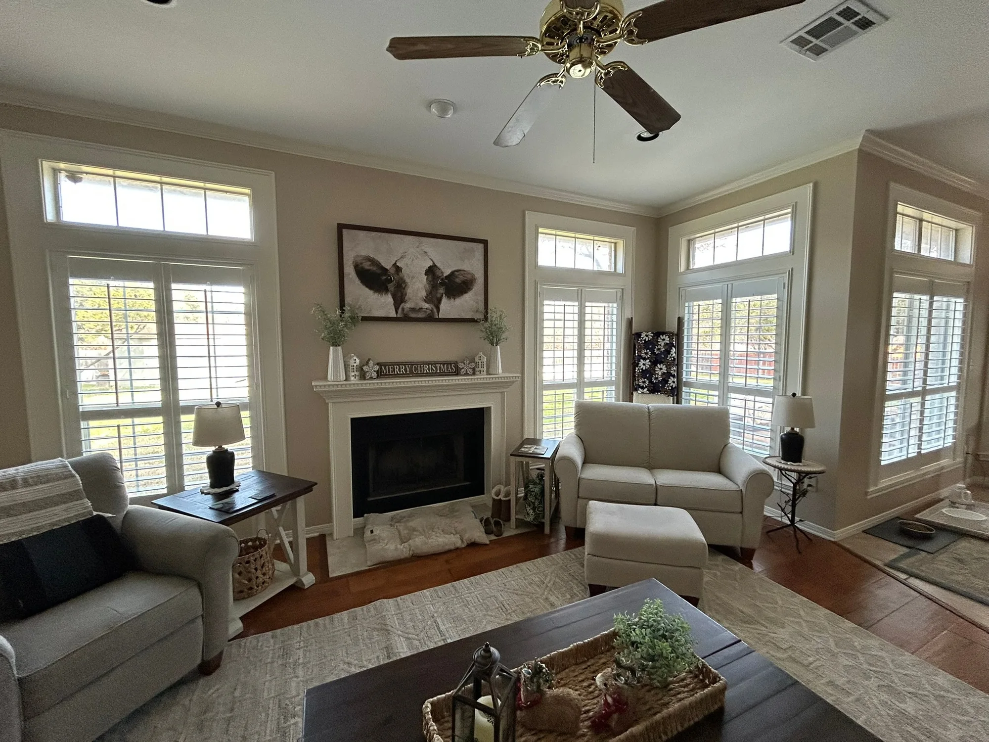 Bright living room with plantation shutters installed by Love Is Blinds