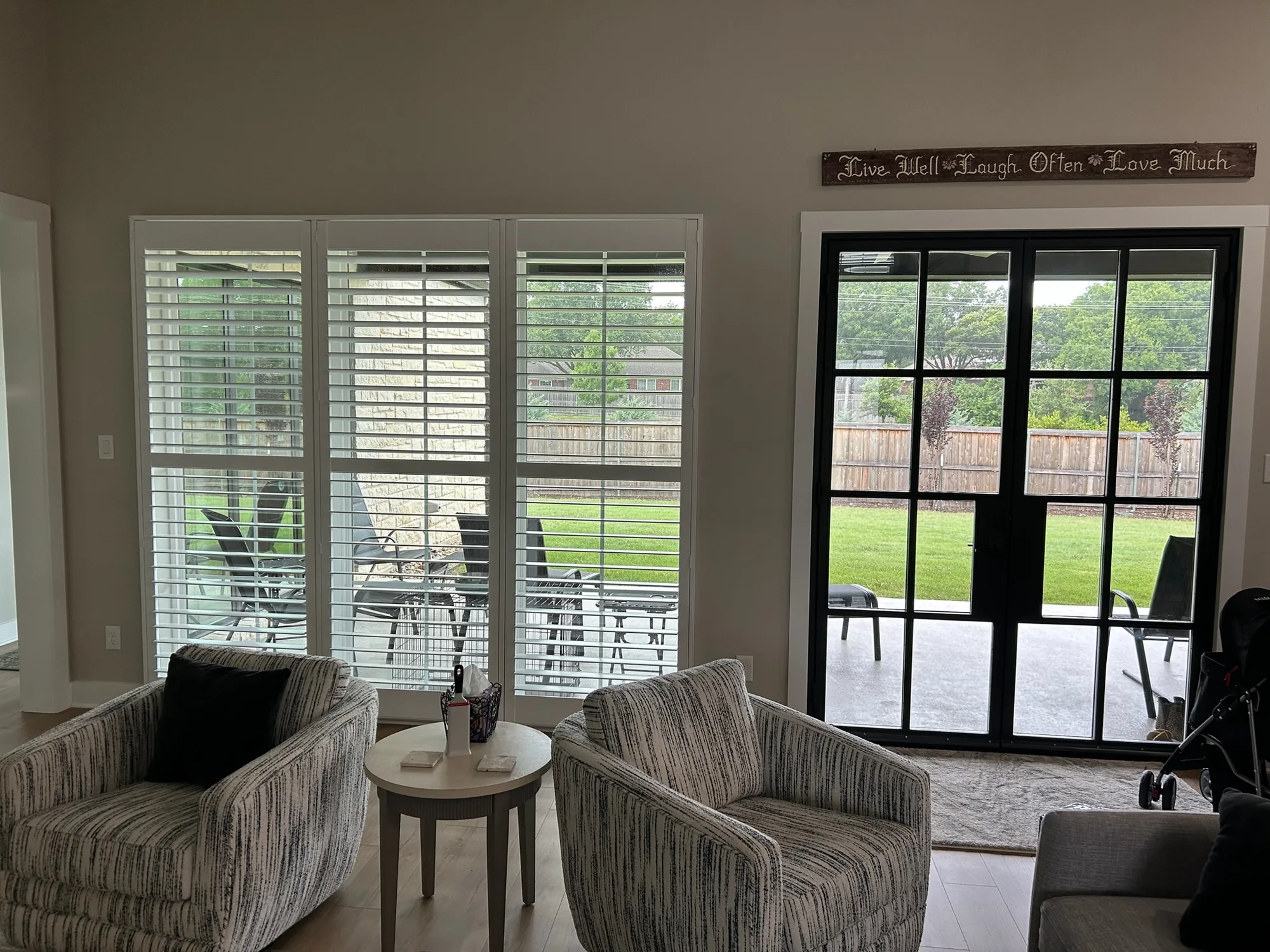 Sitting room with plantation shutters installed by Love Is Blinds